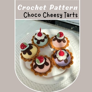 Puede incluir: Cinco mini tartas de crochet con coberturas de chocolate, crema batida y fresas. Las tartas están dispuestas en un plato blanco. La imagen se titula "Crochet Pattern Choco Cheesy Tarts".