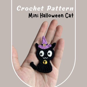 Può includere: Un gatto nero all'uncinetto fatto a mano con un cappello da strega viola con fibbia dorata e campanella dorata. Il gatto ha grandi occhi bianchi ed è etichettato "Crochet Pattern Mini Halloween Cat".