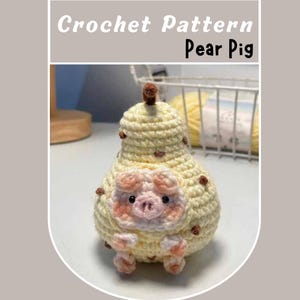 Op de afbeelding: Een gehaakt amigurumi-speelgoed in de vorm van een peer met een varkensgezicht. De peer is geel met bruine vlekken en het varken heeft roze oren, een roze snuit en zwarte ogen.