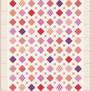 Puede incluir: Una colcha con fondo blanco y un patrón de rombos rosas, rojos, morados y blancos. Los rombos están dispuestos en una cuadrícula y tienen diferentes patrones dentro, incluyendo lunares, corazones y cuadrados pequeños.