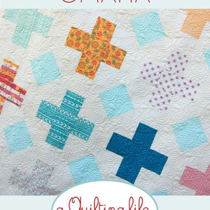 May include: A quilting pattern called "Omaha" featuring a white background with colourful plus signs and diamond shapes. The pattern is from "a quilting life DESIGNS by Sherri McConnell".