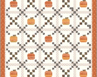 Puede incluir: Una colcha acolchada con un patrón repetido de calabazas naranjas sobre un fondo crema. Las calabazas están rodeadas por una cuadrícula de cuadrados grises y negros con detalles florales. El borde es naranja.