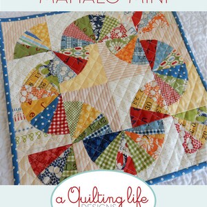 May include: A colourful quilt block pattern with a circular design featuring a variety of fabrics, including red, blue, yellow, green, and white. The quilt block is surrounded by a white background with a light blue border. The text "Mahalo Mini" is written in red at the top of the image. The text "a Quilting life DESIGNS by Sherri McConnell" is written in black at the bottom of the image.