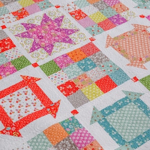 May include: A colorful patchwork quilt with a variety of floral patterns in shades of pink, green, orange, red, and blue. The quilt is made up of squares and rectangles, and the seams are quilted with a decorative stitch.