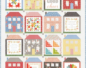 May include: A quilt with a patchwork design of houses. Each house has a different pattern and color. The quilt has a white background and the houses are arranged in a grid pattern. The quilt includes the text "Be of good cheer".