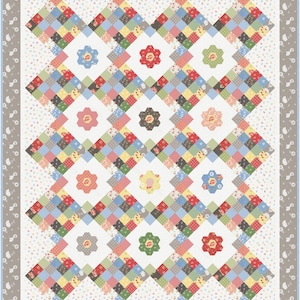 May include: A quilt with a patchwork design featuring a variety of colorful fabrics. The quilt is made up of squares and diamonds, and it has a white background with a subtle floral pattern. The quilt is bordered with a gray and white floral pattern.
