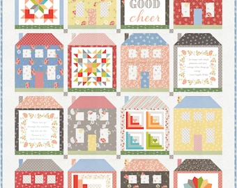 May include: A quilt with a patchwork design of houses. Each house has a different pattern and color. The quilt has a white background and the houses are arranged in a grid pattern. The quilt includes the text "Be of good cheer".