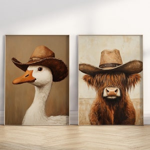 Könnte beinhalten: Zwei gerahmte Kunstdrucke mit einer Gans und einer Hochlandkuh, die jeweils einen braunen Cowboyhut tragen. Die Gans hat weiße Federn und einen orangefarbenen Schnabel. Die Kuh hat langes, zotteliges braunes Fell. Die Hintergründe sind neutral.