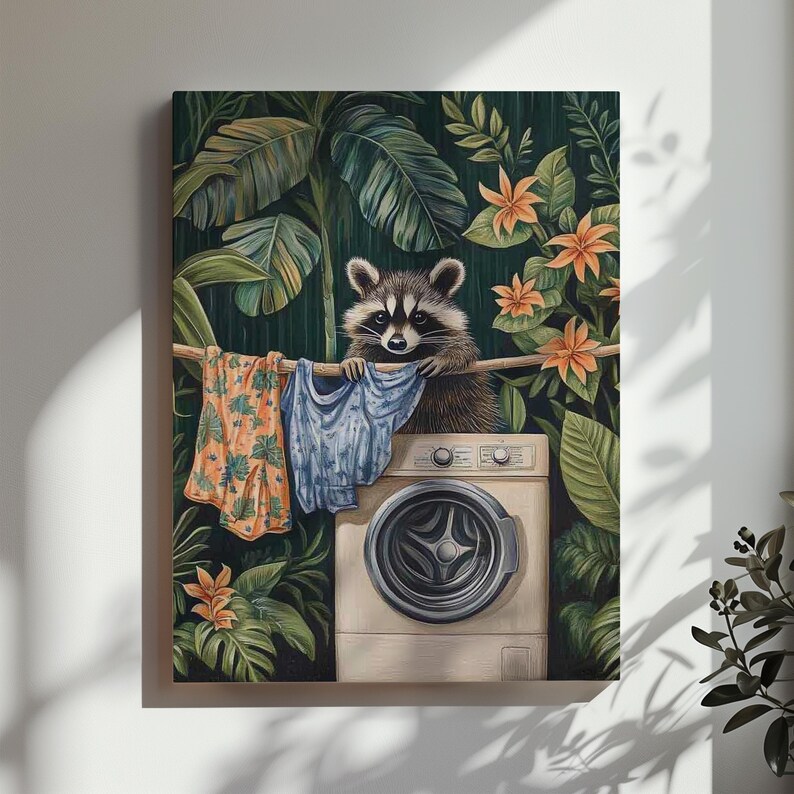 May include: A whimsical art print featuring a raccoon holding laundry above a washing machine. The raccoon is surrounded by lush green foliage and orange flowers. Clothes are hanging on a line. The artwork has a tropical theme.