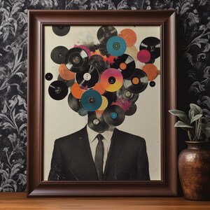 May include: Framed art print featuring a man in a suit with a head composed of colorful vinyl records. The records are in various colors, including orange, pink, and blue. The frame is a dark brown color, and the background is a neutral tone.