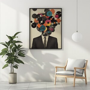 May include: Framed art print featuring a man in a suit with a head composed of colorful vinyl records. The artwork has a vintage aesthetic, with a neutral background and a black frame. The records are in various colors, including blue, orange, and pink.