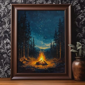May include: A framed painting depicts a campfire scene at night. The artwork features a vibrant orange campfire in the foreground, surrounded by dark trees and a starry sky. The frame is a dark brown color, and the overall theme is nature and camping.