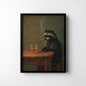 May include: A framed art print featuring a raccoon sitting at a small wooden table, smoking a cigarette, and with a glass of amber liquid. The raccoon is depicted in a realistic style against a muted green background.