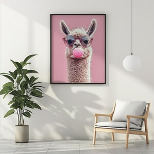 May include: A white llama with pink sunglasses and a pink bubble blowing out of its mouth. The llama is against a pink background.
