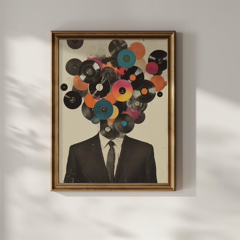 May include: Framed art print featuring a man in a suit with a head composed of colorful vinyl records. The records are various colors, including black, orange, pink, and blue. The artwork is in a gold-colored frame.