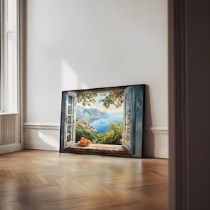 May include: A framed print of a painting depicting a window overlooking a coastal town and a blue sea. The window is open and there are oranges in a bowl on the windowsill.