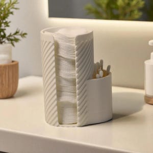 May include: A white plastic bathroom organiser featuring a tall cylindrical section with a vertical opening filled with round cotton pads and a shorter adjacent compartment containing several white cotton swabs with a textured diagonal ribbed pattern.