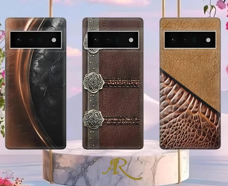 Puede incluir: Tres fundas para tel&eacute;fono con dise&ntilde;os &uacute;nicos. La primera tiene un patr&oacute;n oscuro y texturizado con detalles en bronce. La segunda es de cuero marr&oacute;n con adornos plateados decorativos. La tercera presenta una combinaci&oacute;n de cuero beige y textura de reptil.