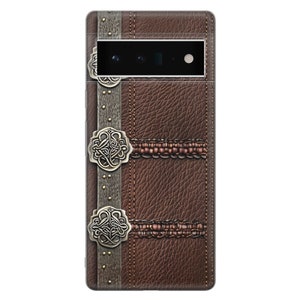 Puede incluir: Una funda de tel&eacute;fono de cuero marr&oacute;n con una superficie texturizada, detalles met&aacute;licos decorativos y un dise&ntilde;o cosido. La funda tiene una apariencia vintage, similar a un libro, con un recorte para la c&aacute;mara en la parte superior.