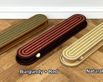 May include: Three cribbage boards in oak, burgundy, and natural colors. Each board features a rope design and includes wooden pegs. The boards are labeled "Oak + Green", "Burgundy + Red", and "Natural + Natural".