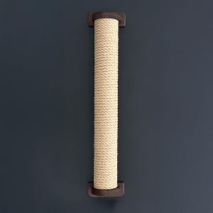 May include: A beige rope cat scratching post mounted on a dark blue wall. The post is cylindrical, made of tightly wound rope, and has dark brown wooden end caps. This cat accessory provides a surface for scratching and climbing.