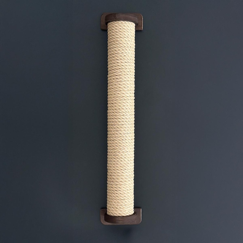 May include: A beige rope cat scratching post mounted on a dark blue wall. The post is cylindrical, made of tightly wound rope, and has dark brown wooden end caps. This cat accessory provides a surface for scratching and climbing.