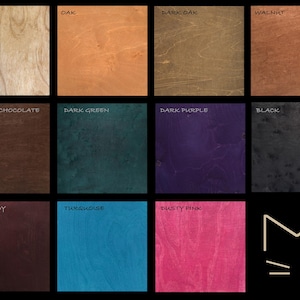 May include: A collection of wood samples in various colors, including Natural, Oak, Dark Oak, and Walnut. Other colors include Belgian Chocolate, Dark Green, Dark Purple, Black, Burgundy, Turquoise, and Dusty Pink. A cat face logo is in the bottom right corner.