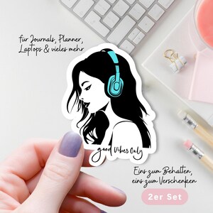 Könnte beinhalten: Ein weißer Aufkleber mit einer Schwarz-Weiß-Illustration einer Frau mit türkisfarbenen Kopfhörern. Der Aufkleber trägt den Schriftzug "good vibes only". Der Text oben lautet "für Journals, Planner, Laptops & vieles mehr".