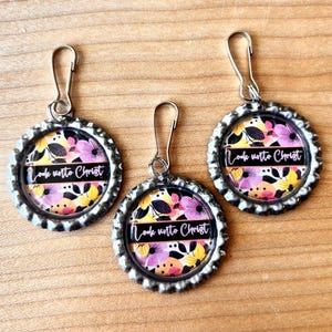 May include: Three silver zipper pulls with floral designs and the text "Look unto Christ" in pink lettering.