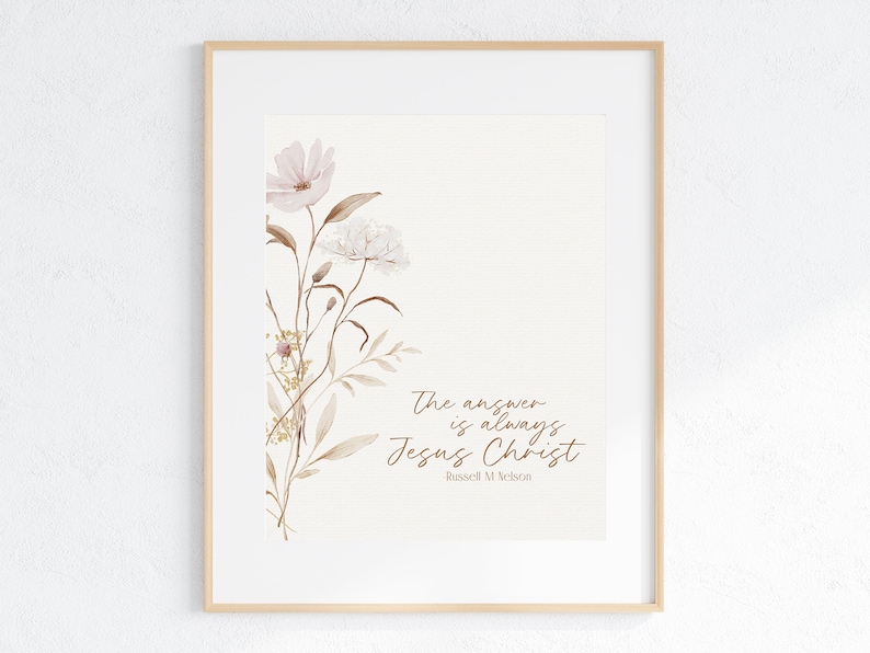 May include: A watercolor print with a quote about Jesus Christ. The quote reads "The answer is always Jesus Christ" by Russell M. Nelson. The print features a floral design with pink and white flowers and brown stems.
