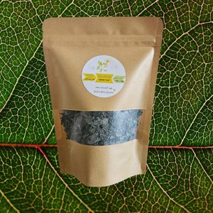 May include: A brown paper bag with a white circle label that says "Mama's Loose Tea" and "Net Wt 1 oz / 28g". The bag contains loose tea leaves.