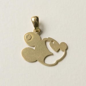 K&ouml;nnte beinhalten: Goldfarbener Anh&auml;nger in Form einer Zeichentrickfigur. Der Anh&auml;nger hat oben eine Schlaufe f&uuml;r eine Kette und ein kleines, kreisf&ouml;rmiges Detail mit Text. Das Design ist eine Silhouette einer ber&uuml;hmten Zeichentrickfigur.