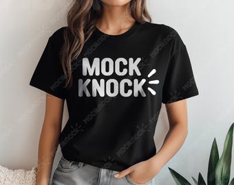 May include: Black t-shirt with the text "MOCK KNOCK" in white, with stylized lines on the right side. The shirt is a crew neck style and is being worn by a person.