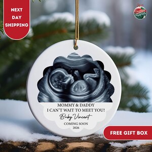 May include: White ceramic ornament with a baby ultrasound image. Text reads "Mommy & Daddy I can't wait to meet you! Baby Vincent Coming Soon 2026." Gold string for hanging. Includes "Next Day Shipping" and "Free Gift Box" labels.