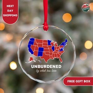 May include: A glass ornament featuring a map of the United States with states colored red and blue. The ornament has the text "UNBURDENED by what has been" below the map.