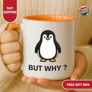 May include: White ceramic mug with an orange interior and handle. The mug features a cartoon penguin illustration in black, white, and yellow, with the phrase "BUT WHY ?" printed below the penguin. A fun gift idea.