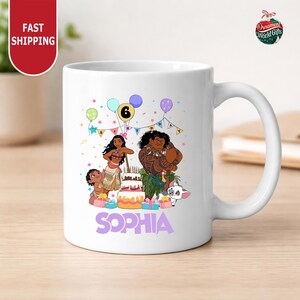 A white ceramic mug with a colorful illustration of characters from the Disney movie Moana, including Moana herself, surrounded by birthday decorations and balloons.