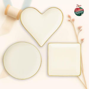 three white plates with gold trim, arranged in a triangular formation on a light background.