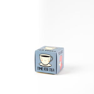 May include: A blue box with a cartoon teacup and the text "Time for Tea". The box also has the text "Tea-Rex" and "Tea Socks" on the sides.