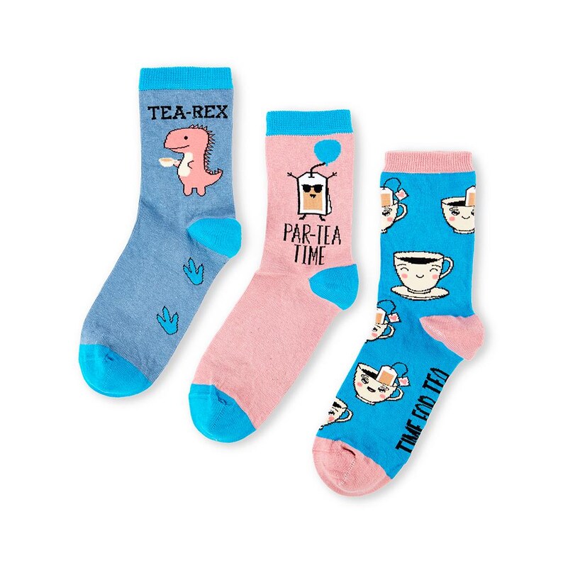 May include: Three pairs of colorful socks with fun tea-themed designs. One pair features a dinosaur with the text "Tea-Rex", another pair has a tea bag with the text "Par-Tea Time", and the third pair has a teacup with the text "Time for Tea".