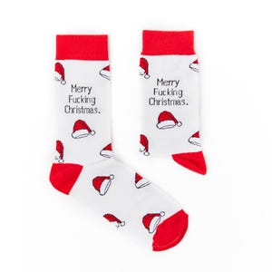 May include: A pair of white socks with red accents at the toe and cuff. The socks feature a pattern of Santa hats and the text "Merry Fucking Christmas."