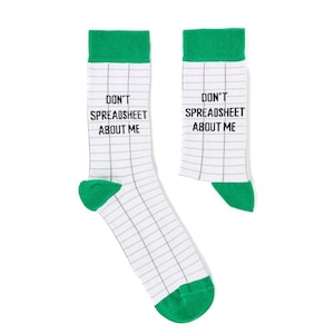 Puede incluir: Un par de calcetines blancos con puños verdes. Los calcetines tienen un patrón de cuadrícula y el texto "DON'T SPREADSHEET ABOUT ME" está impreso en cada calcetín.