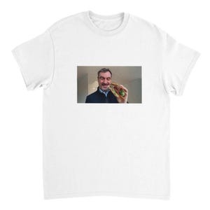Könnte beinhalten: Ein weißes T-Shirt mit einem Foto eines Mannes, der ein Sandwich vor seinem Gesicht hält. Der Mann trägt eine dunkelblaue Jacke und hat einen hellen Bart.