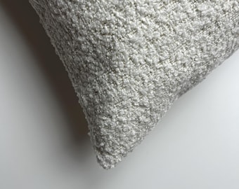 May include: Close-up of a white, fluffy pillow with a textured surface.