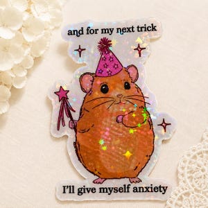 Könnte beinhalten: Ein holografischer Aufkleber mit einem braunen Hamster, der einen rosa Partyhut mit Sternen trägt. Der Hamster hält einen rosa Zauberstab mit Sternspitze. Der Text lautet oben "and for my next trick" und unten "I'll give myself anxiety".