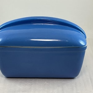 May include: A set of three ceramic mugs with a speckled, cream-colored glaze. Each mug features a different hand-painted floral design in shades of blue, green, and yellow. The mugs have a simple, rounded shape and a comfortable handle.