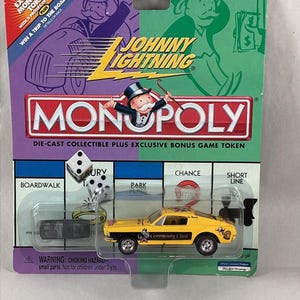 May include: A die-cast Johnny Lightning Monopoly car in a blister pack. The yellow car has black accents and the words "Community Chest" on the side. The packaging features Monopoly branding and the text "Win a trip to the Boardwalk".