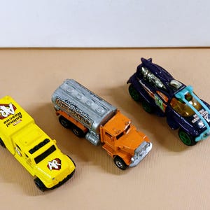 Vintage 3 Diecast Trucks, Yellow Animal Rescue Tonka, Oranger California Construction Hot Wheels, and Metro Sanitation Hot Wheels