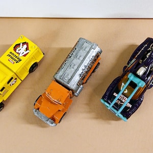 Vintage 3 Diecast Trucks, Yellow Animal Rescue Tonka, Oranger California Construction Hot Wheels, and Metro Sanitation Hot Wheels
