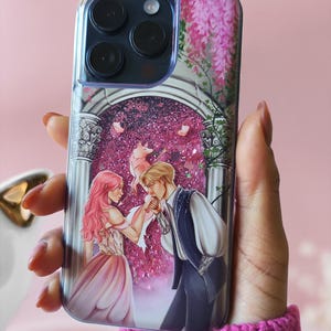 Puede incluir: Una funda transparente para teléfono con un diseño de purpurina rosa que presenta una pareja en un entorno romántico. La funda tiene un diseño floral con flores rosas y un arco blanco.